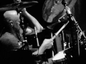 Black-and-white close-up of Gary Moffatt playing drums