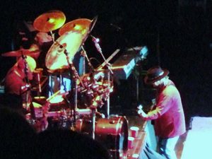 Gary Moffatt and his drum kit viewed from the side of the stage