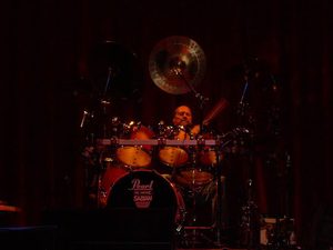 Gary Moffatt and his drum kit under amber stage lights