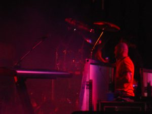 Gary Moffatt performing under red stage lights